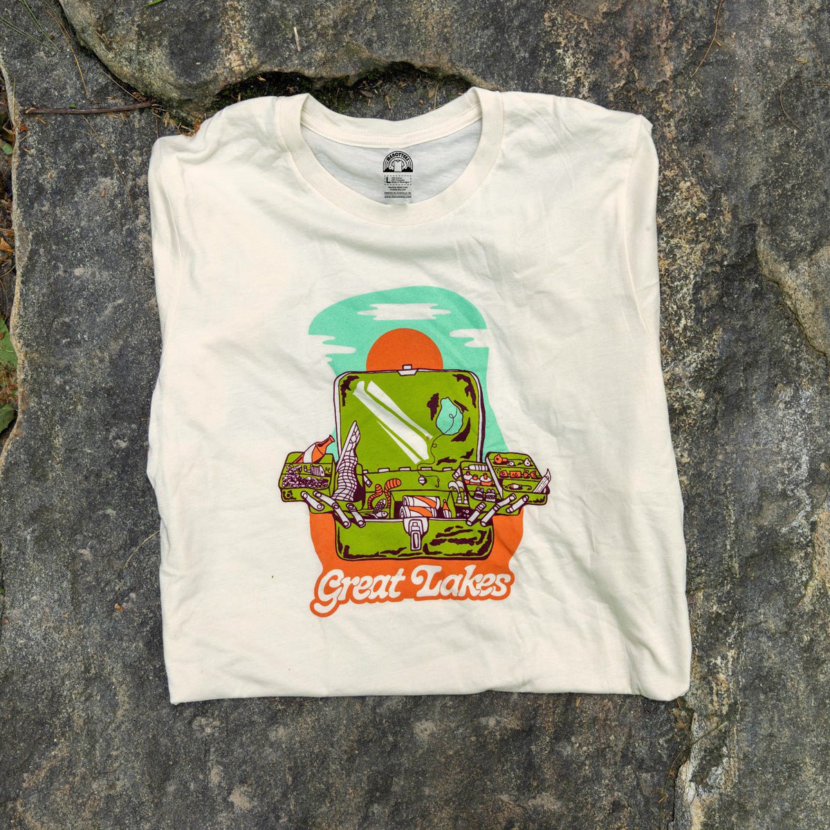 Natural t-shirt with 'Great Lakes' graphic design on a stone surface