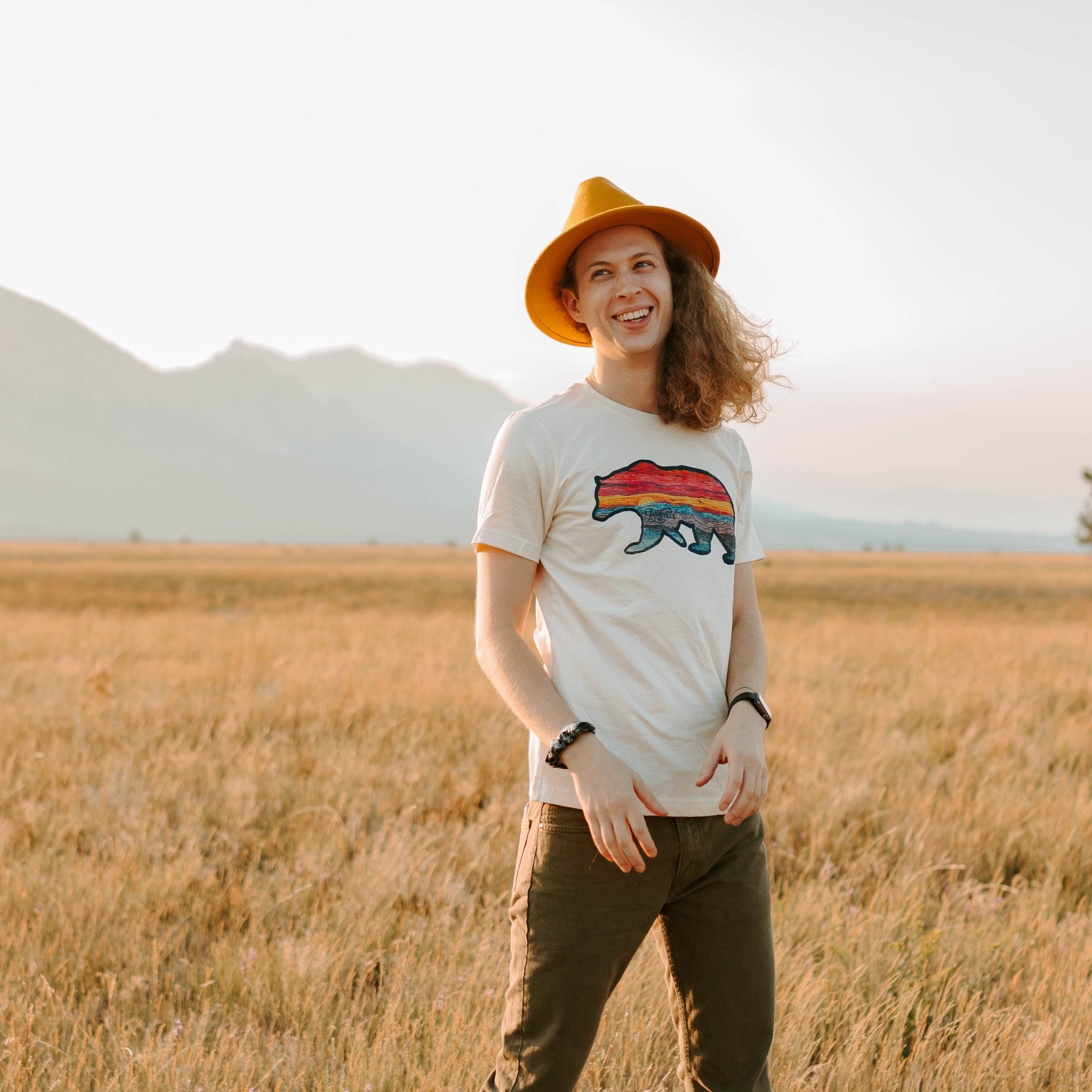 Unisex t-shirt featuring iconic Asheville bear design with rainbow sky