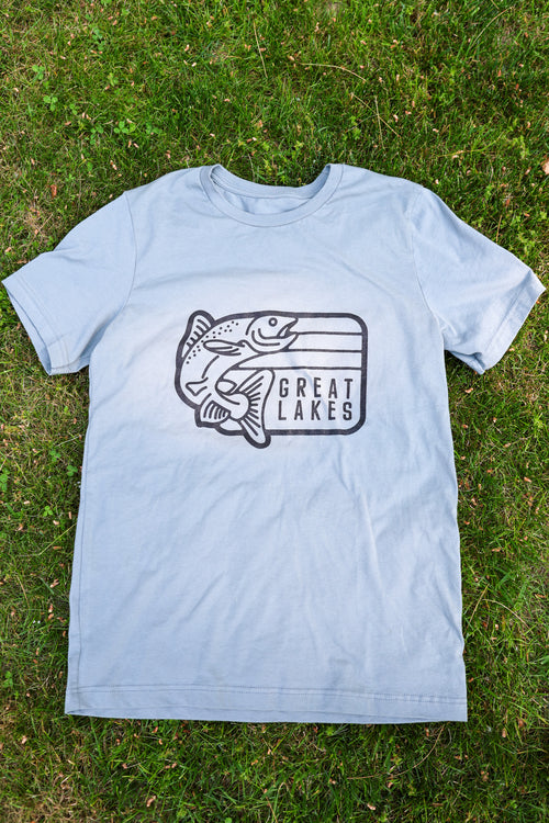 Light blue t-shirt with 'Great Lakes' graphic on grass