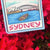 Illustration of Sydney with landmarks on a card surrounded by red flowers