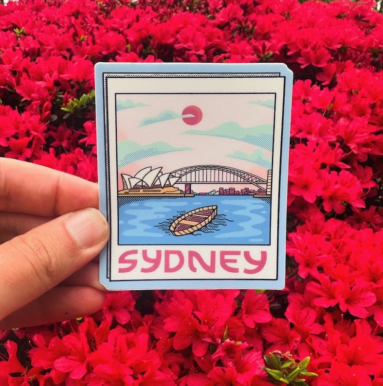 Card with Sydney illustration held over a field of red flowers