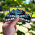 Hand holding three 'Colorado' stickers with mountain design against a blurred green background