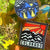 Two stickers with mountain and sun designs on a leafy background