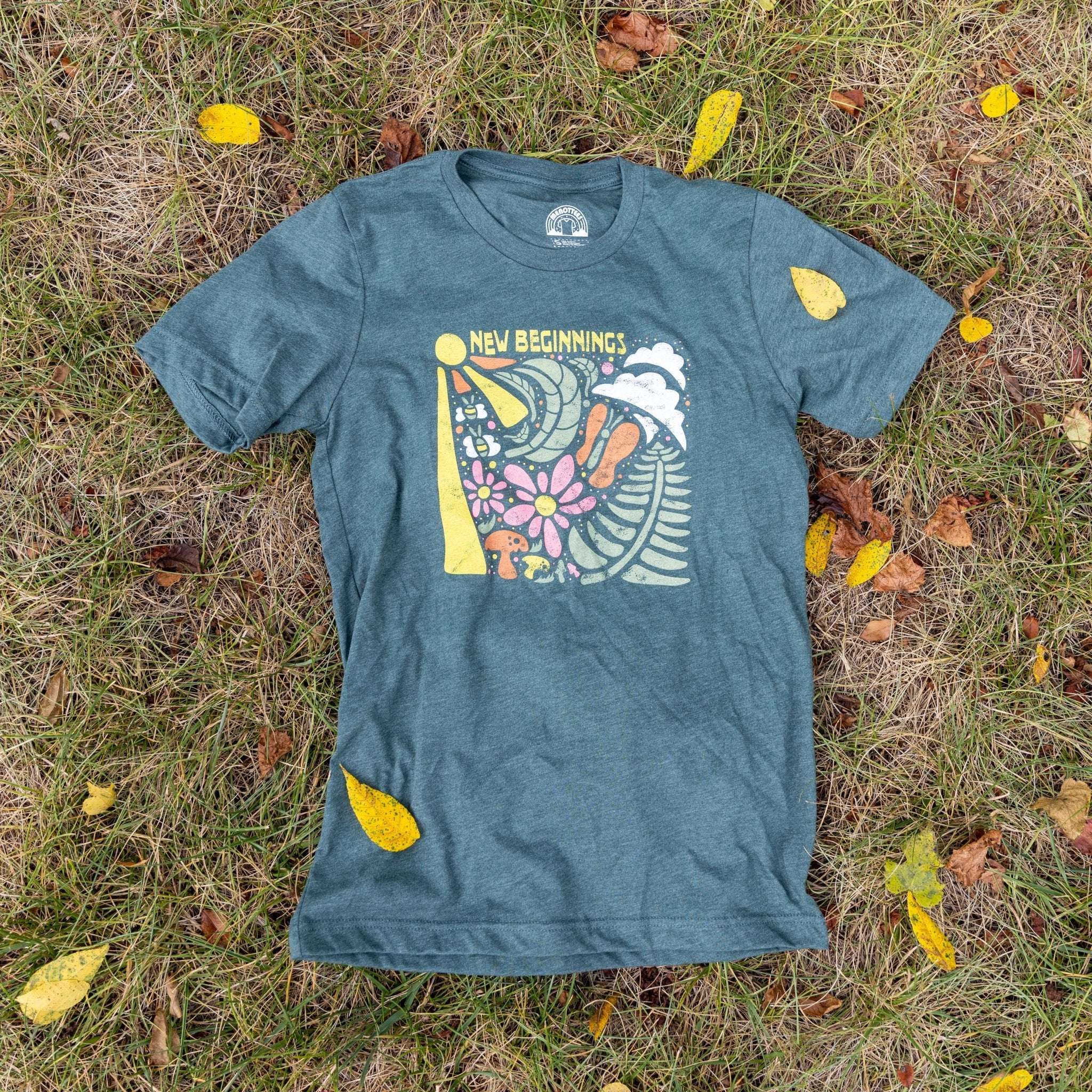 Nature-themed graphic tee with sun, clouds, mushrooms and flowers