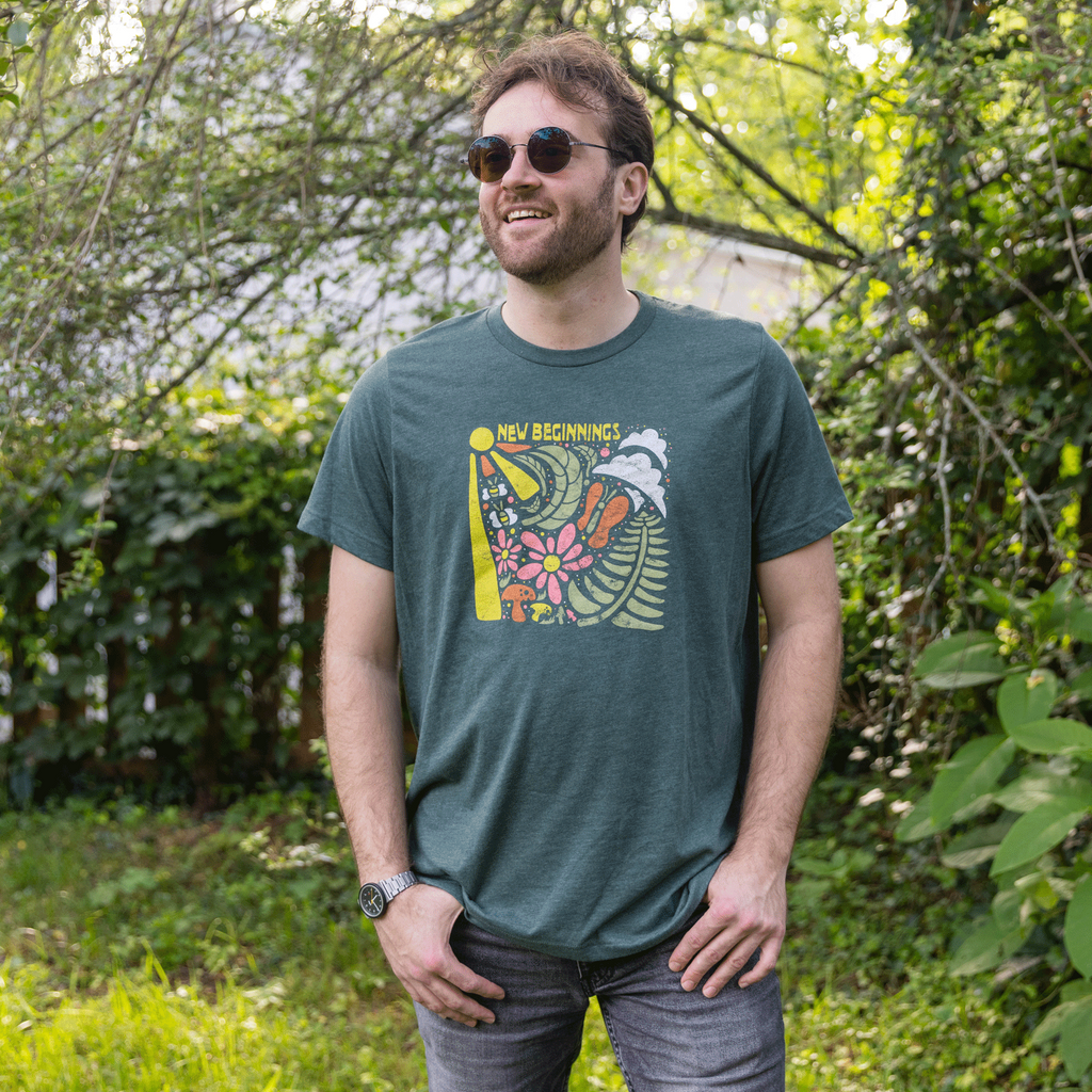 Man wearing a green t-shirt with a colorful graphic design outdoors.