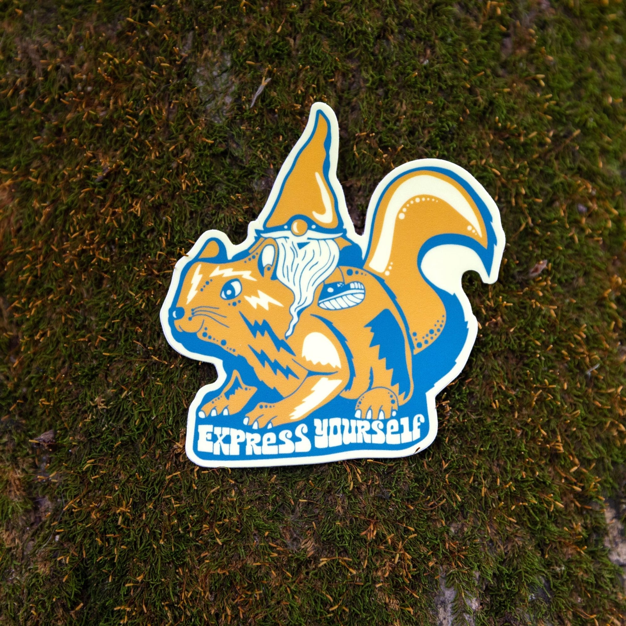 Sticker laying flat on stone or dirt with bold graphic visible

