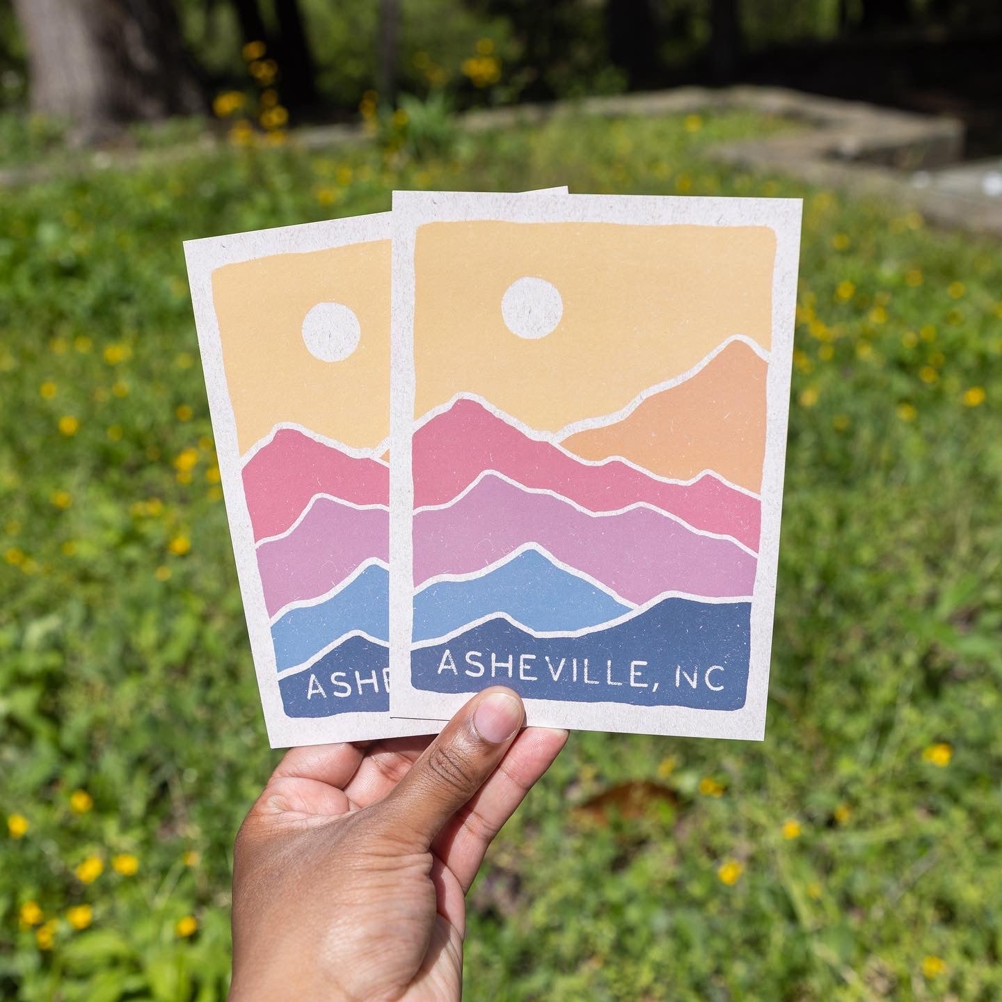 Close-up of the postcard standing upright in grass

