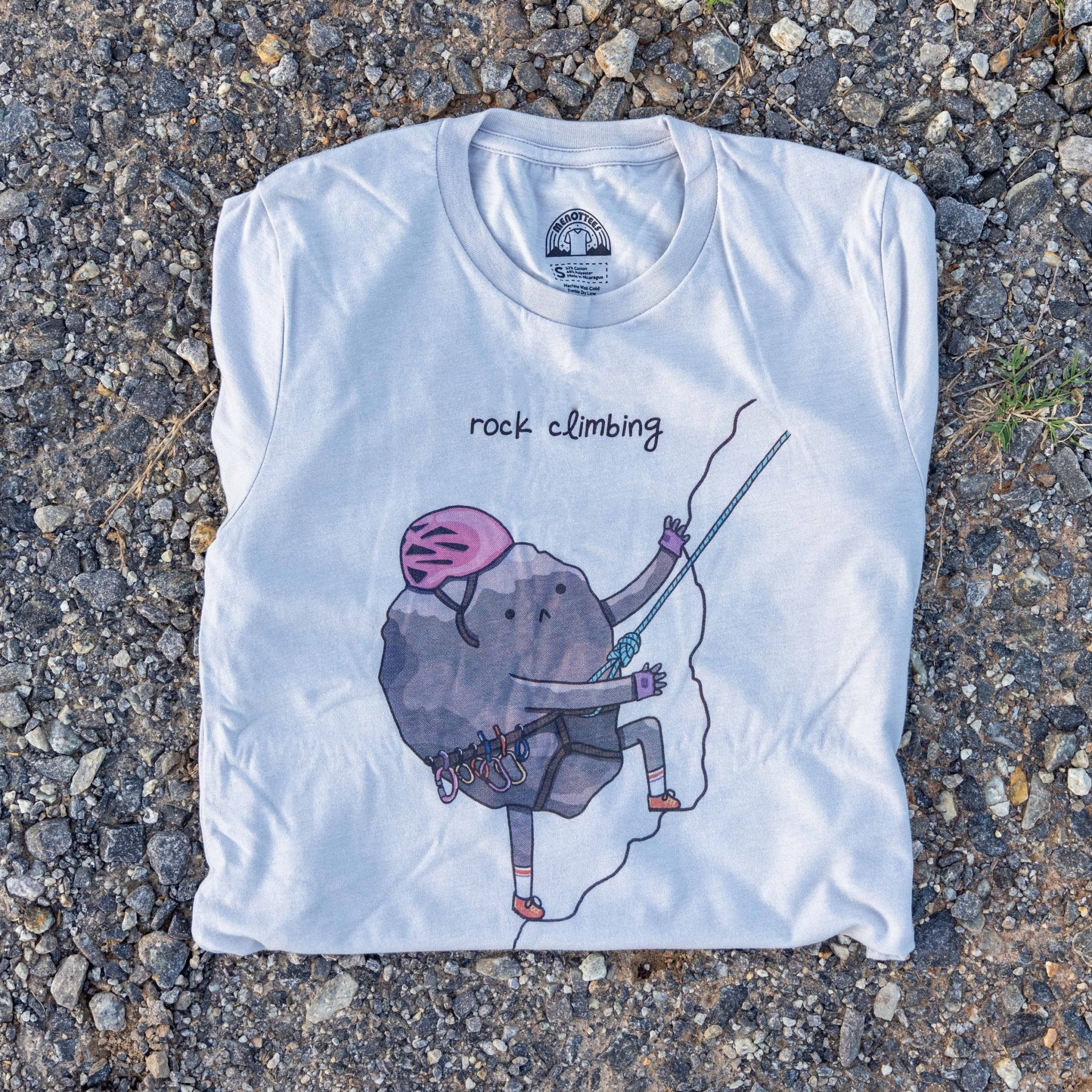 Rock Climbing graphic t-shirt featuring a cartoon rock climbing up a cliff. Unisex fit, soft cotton blend.
