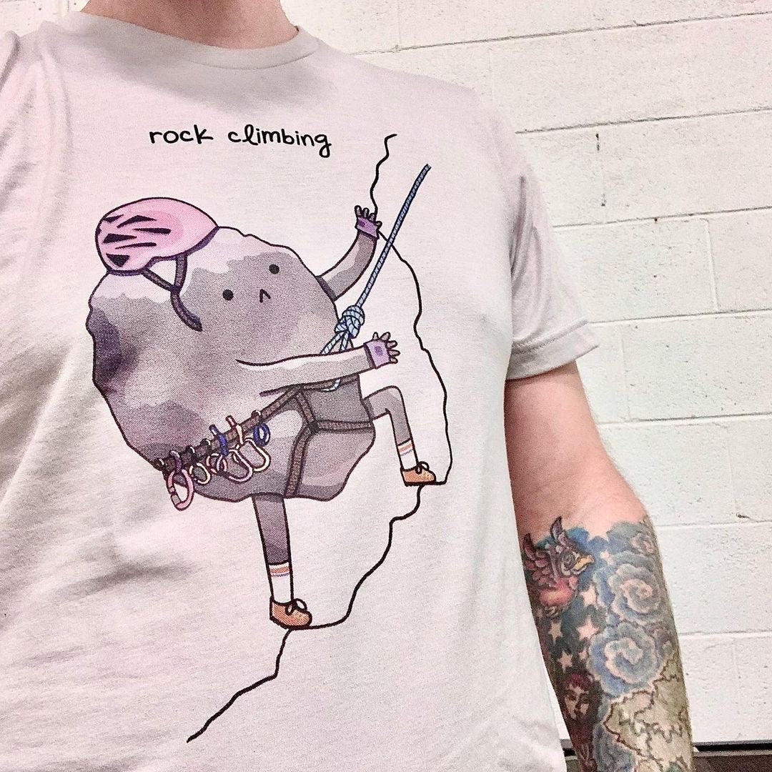 Model wearing the Rock Climbing tee with cartoon boulder illustration. Great for climbers and geology lovers.