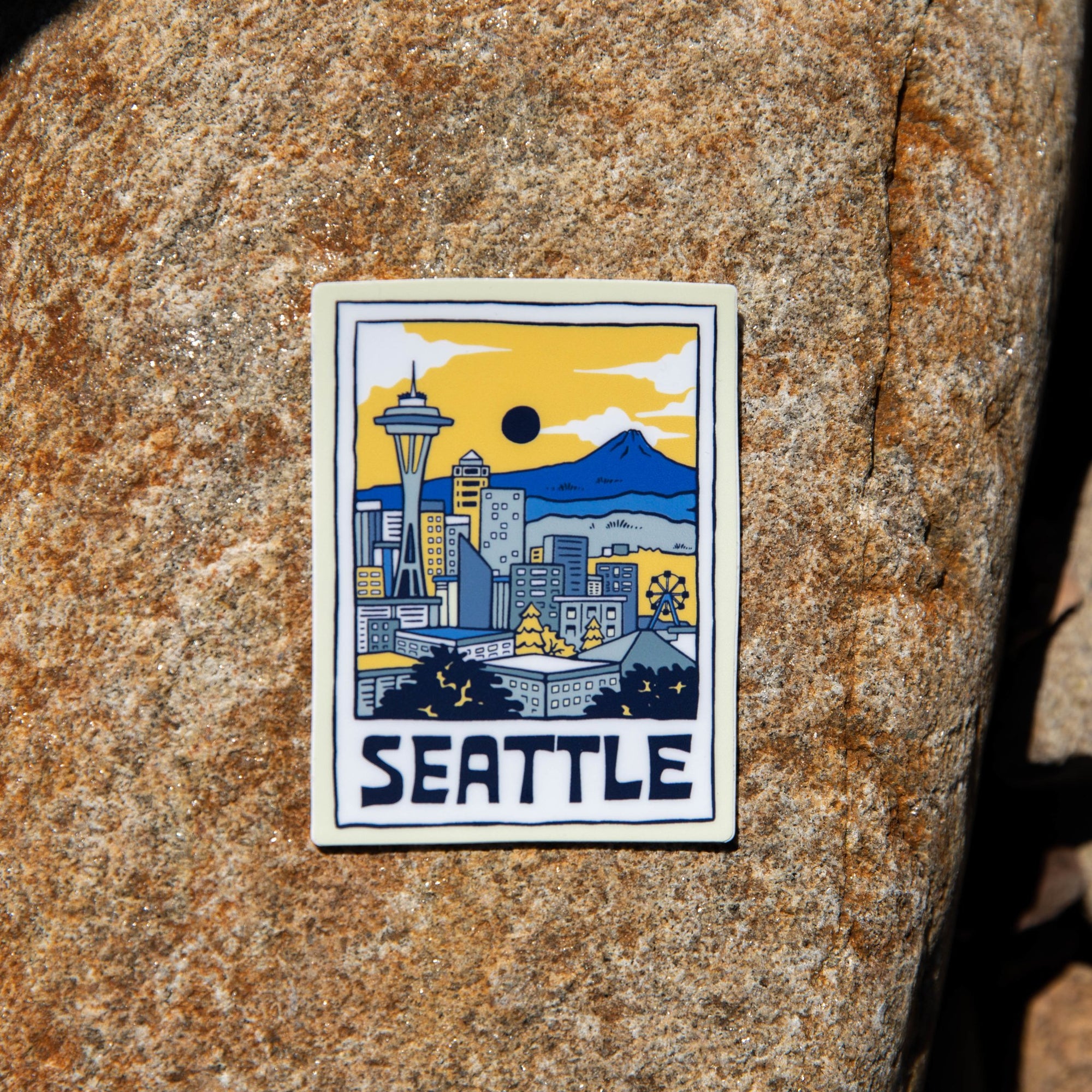 Sticker resting on a stone or wooden surface outdoors

