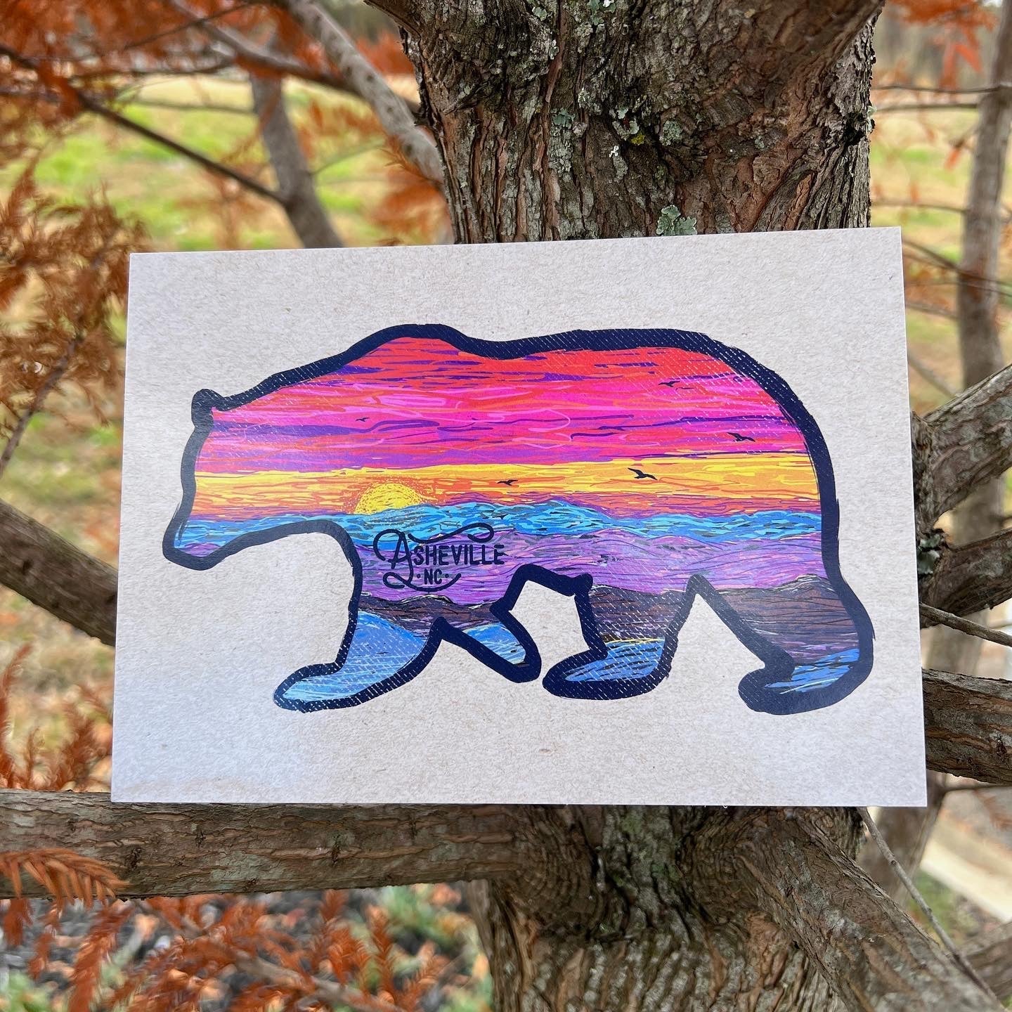 Postcard perched in tree branches with fall leaves in background

